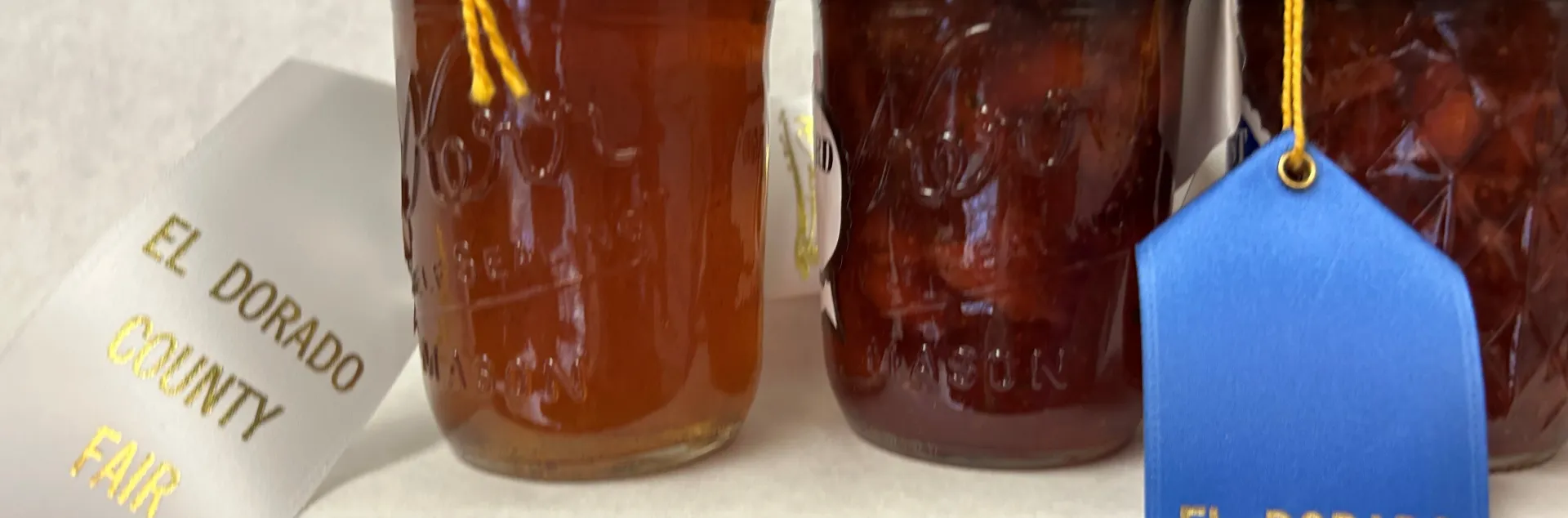 three jars of jellies with county fair ribbons