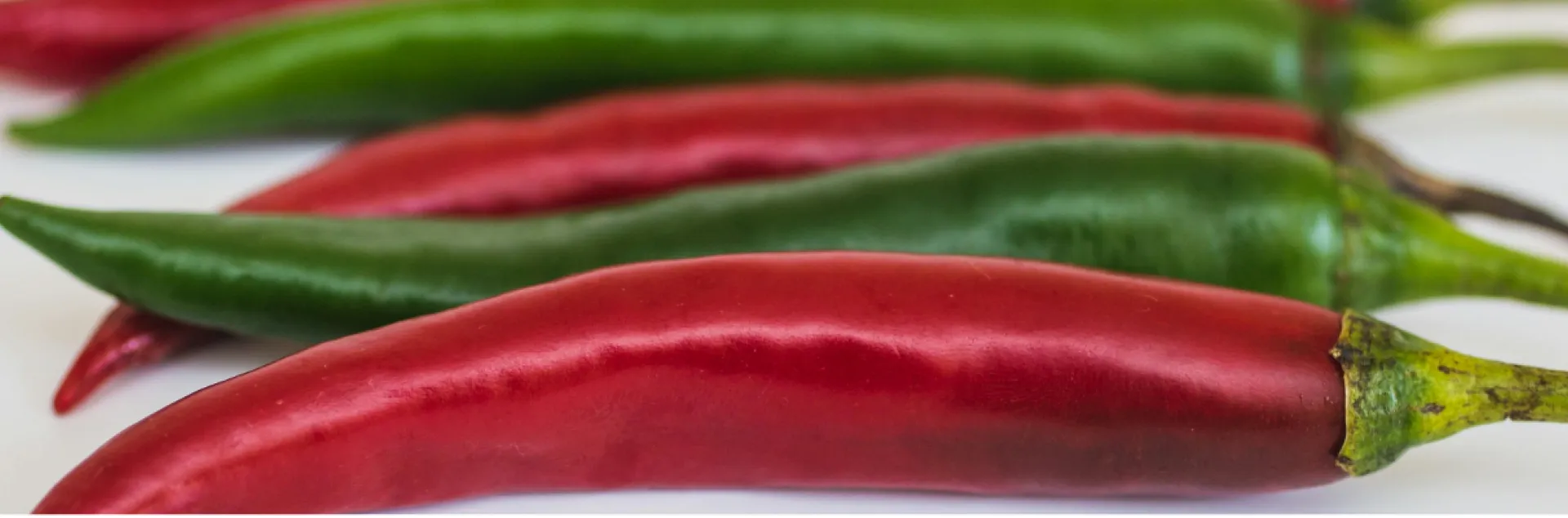 red and green peppers laying in a row