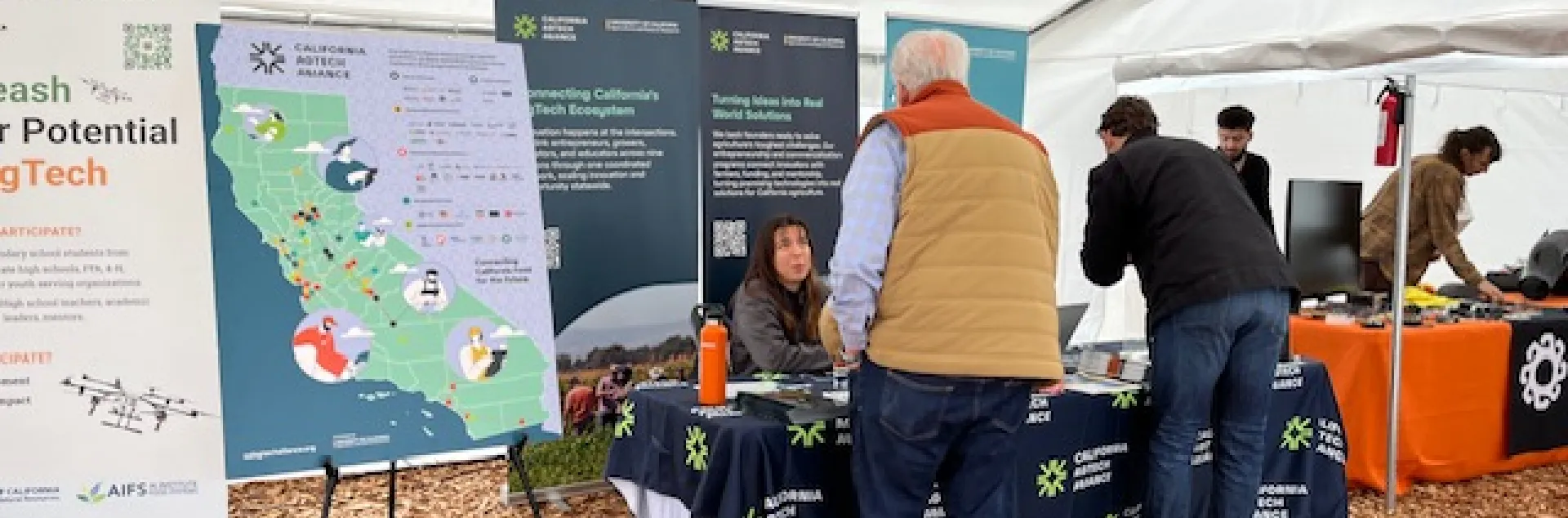 Lucie chats with a man visiting the California AgTech Alliance table