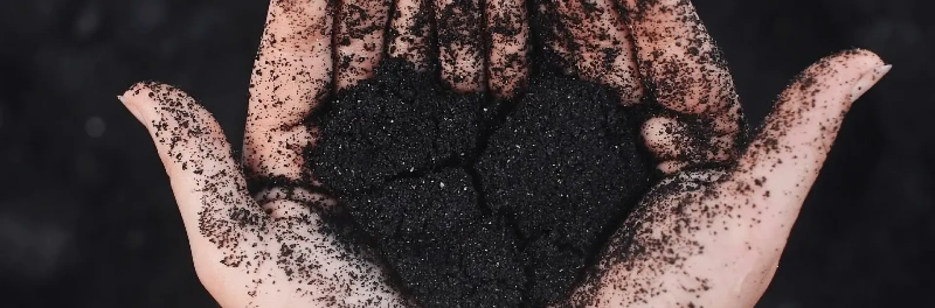 hands holding rich soil in a heart shape
