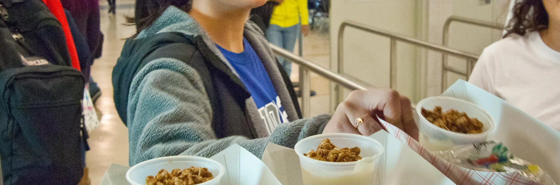 A high school student grabs a prepared meal from the cafeteria.
