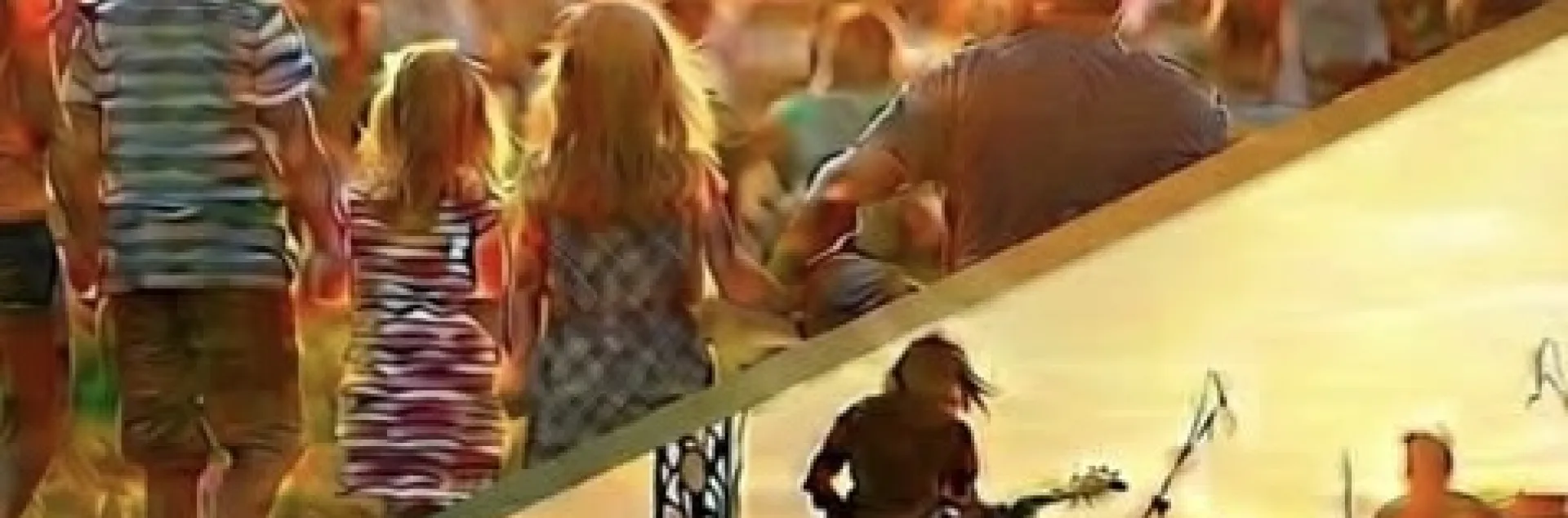 Picture of families walking through a park and a stage with musicians