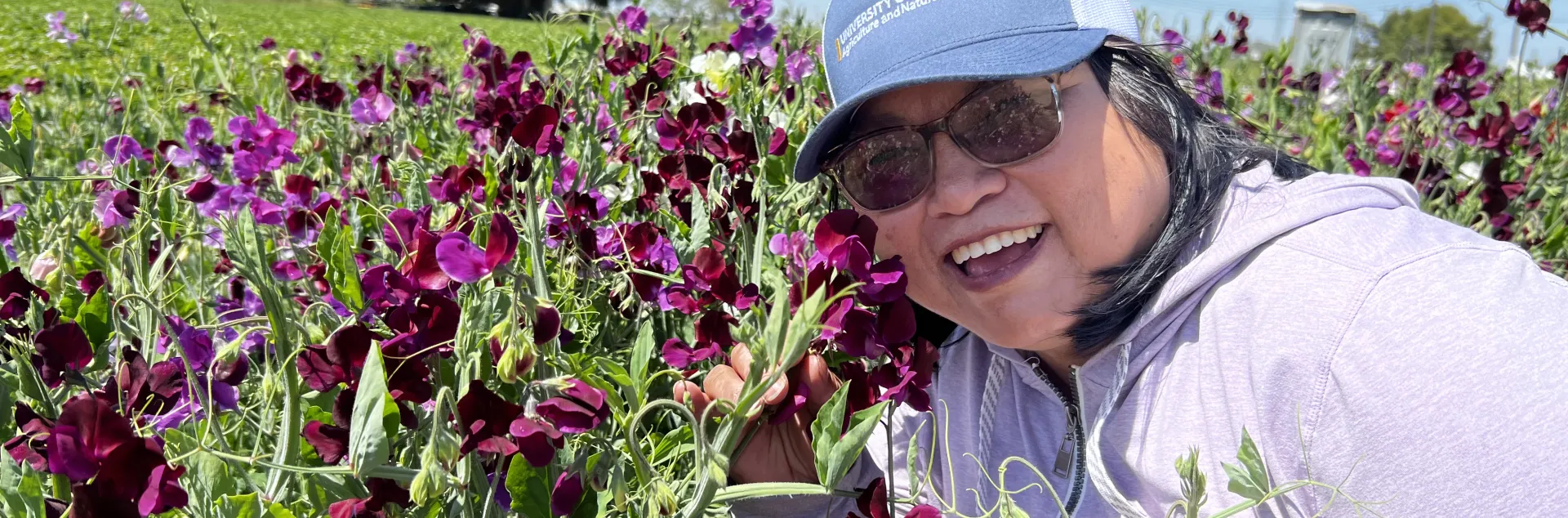 Fam Lee poses up-close with flowers in a field