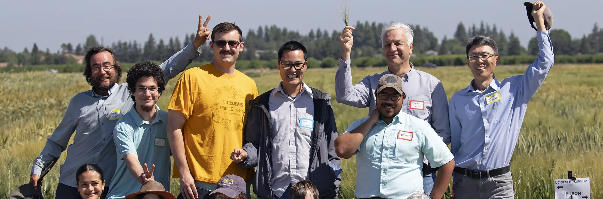 people smiling and waving at camera in a field
