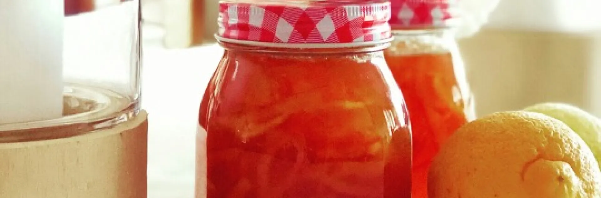 jars of strawberry lemon marmalade with whole lemons in the foreground