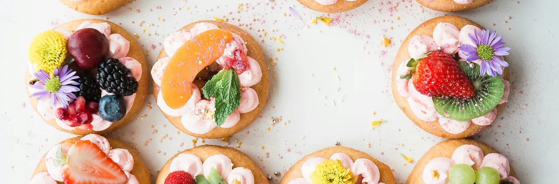Cookies topped with fruits and flowers.