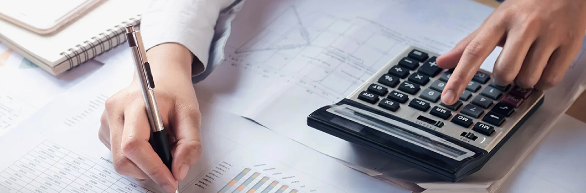person engaged in bookkeeping with notes and a calculator