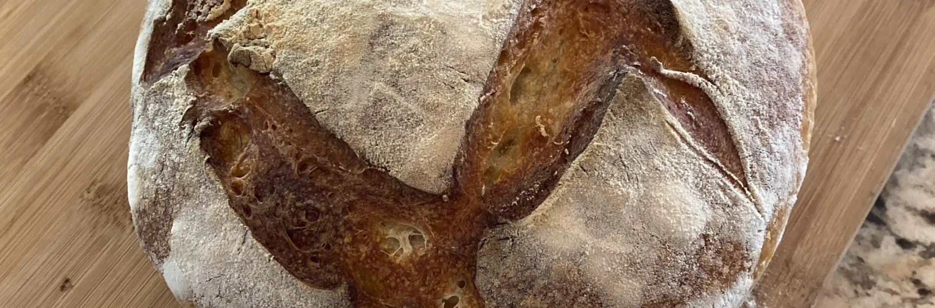 round loaf of sourdough bread on a wooden cutting board