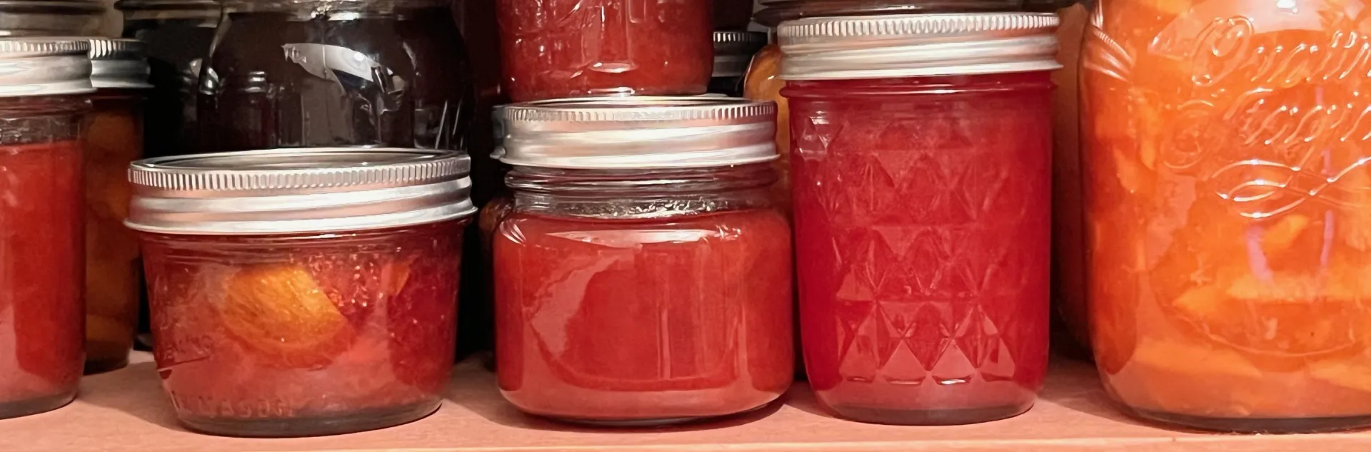 Jars of jams, jellies, and chutneys in a well-stocked pantry. J.C. Lawrence