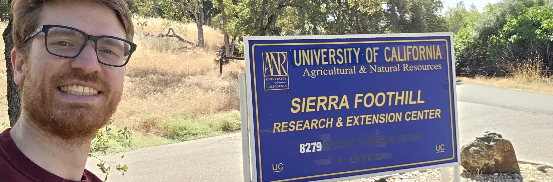 Conor McCabe next to Sierra Foothill Research and Extension Center sign