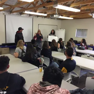students seated in a classroom learning from 3 instructors