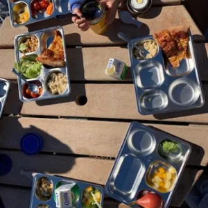 School lunch served on stainless steel reusable trays.