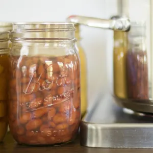 Jars of pinto beans next to canner on a burner. 