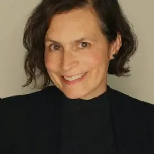woman with short dark hair wearing a black shirt and black blazer