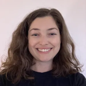 Headshot of a white female with brown hair wearing a black shirt 
