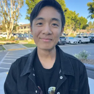 man with black hair wearing a black denim jacket