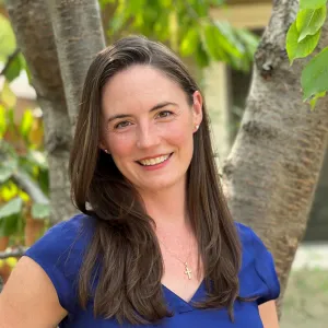 Smiling woman with long brown hair wearing a blue shirt