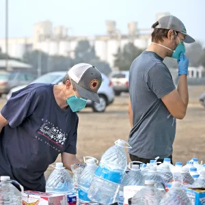 Volunteers handing out bottled water to community members in need.