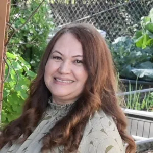 Woman with long brown hair and tan shirt - Maria Hermenegildo