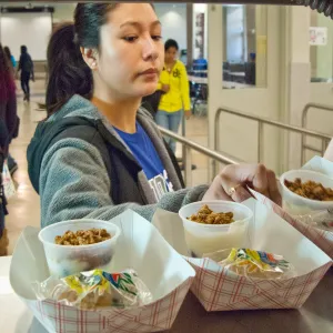 A high school student grabs a prepared meal from the cafeteria.