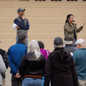 Fire Network members, Katie Low and Bruno Pitton, talking to a group of Placer County residents about wildfire preparedness in front of a home.