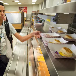 Image of a young adult grabbing breakfast from the school cafeteria.