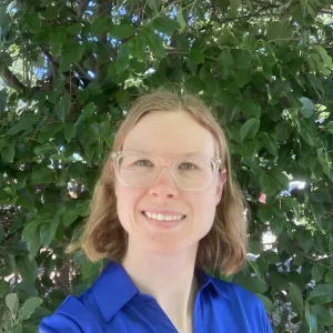 Emma standing in front of a tree.