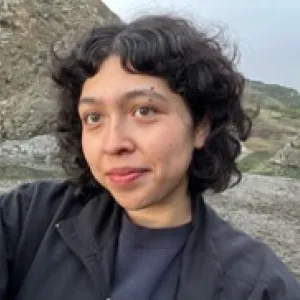 Person posing, beach in background