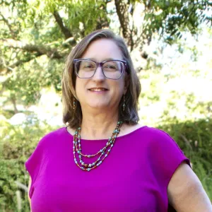 Elizabeth Moon - fuschia shirt in front of trees