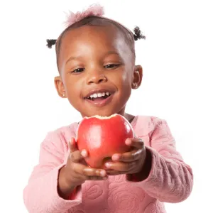 Toddler holding and eating an apple