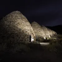 Charcoal kilns lit up at night.