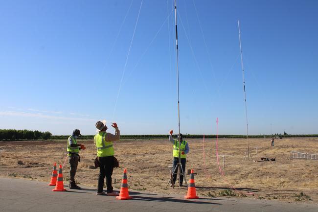 Positioning towers and loading water sensitive cards atop poles at fixed distances from spray.