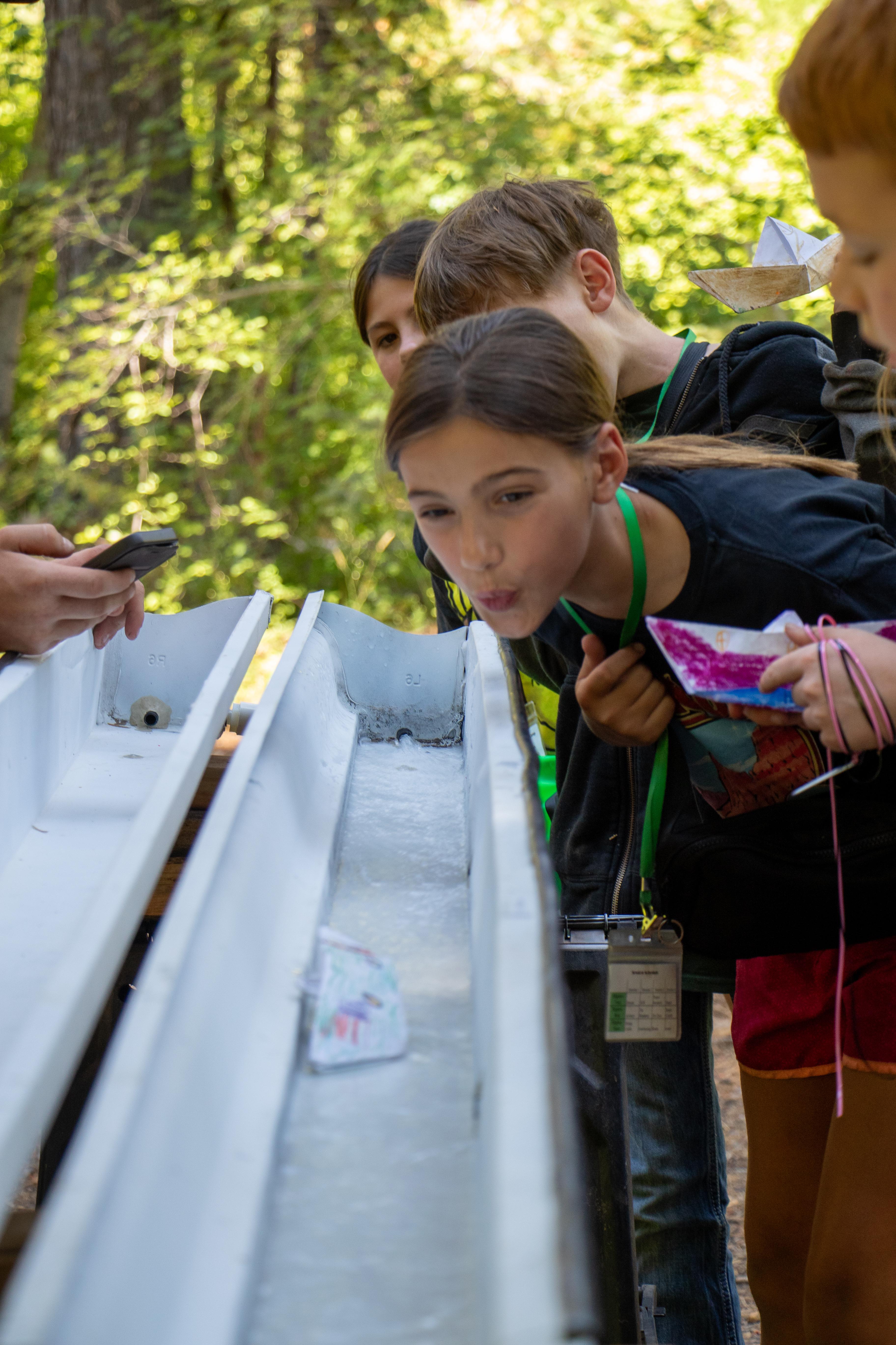 Youth racing boats down streams made of gutters