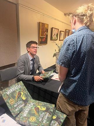 An attendee talks with Dr. Matt Ritter at the book signing.