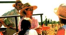 Katherine Kelly explains a farm technique to tour members while her husband Clyde listens in the background.